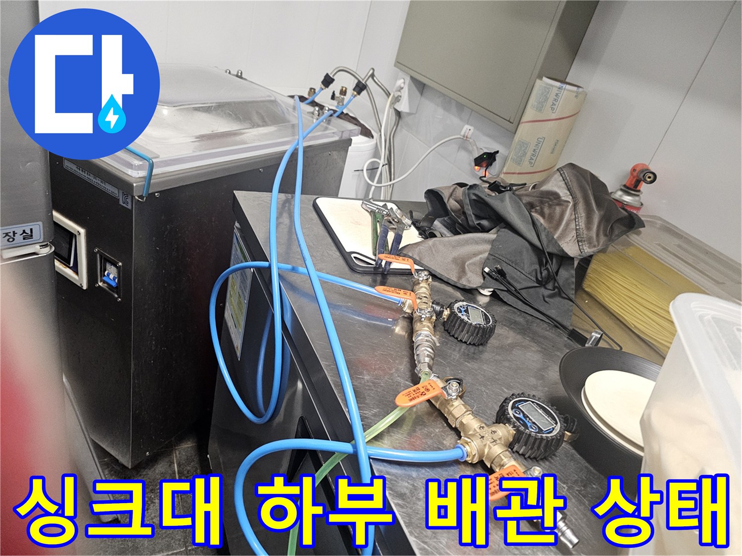 싱크대 아래쪽 금속 밸브와 파란색 호스 연결 부위 촬영