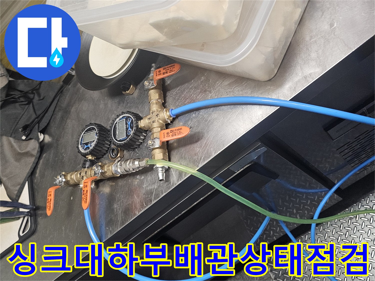 싱크대 하부의 수도 밸브와 급수 호스 연결 부위 사진