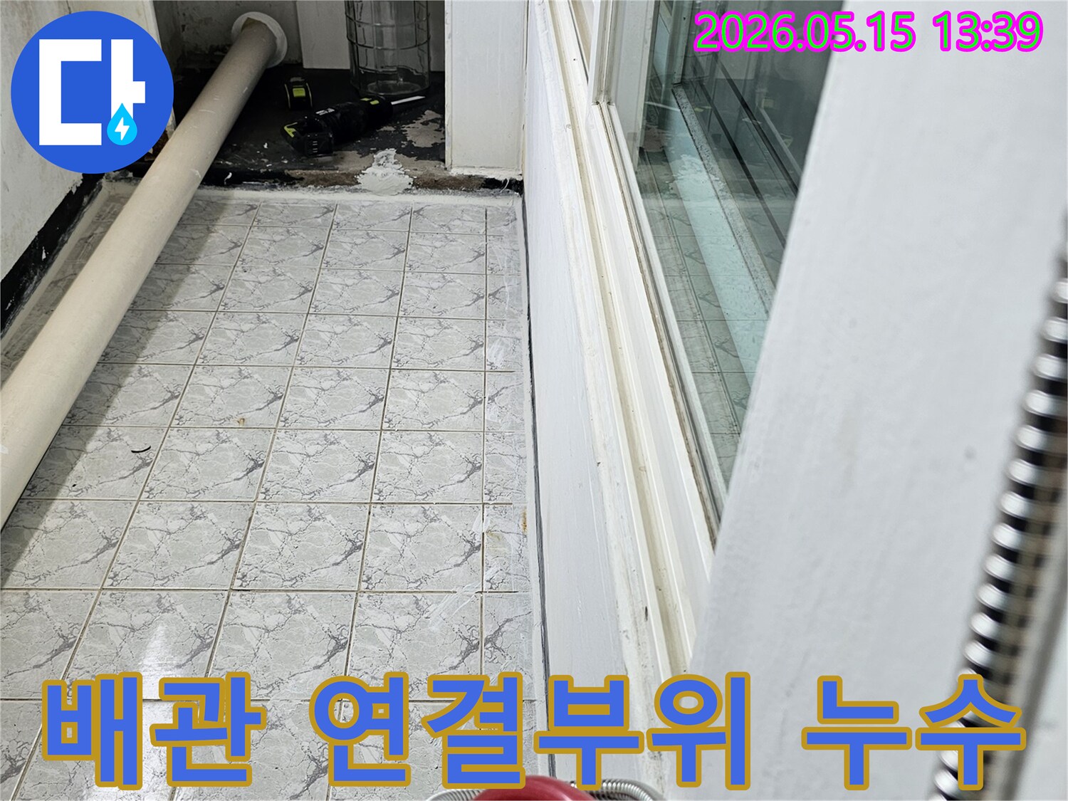이 사진은 의정부 신곡동 아파트의 배관 연결 부위에서 발생한 누수 현장을 포착한 것입니다-주변 타일과 벽면의 물자국이 선명합니다
