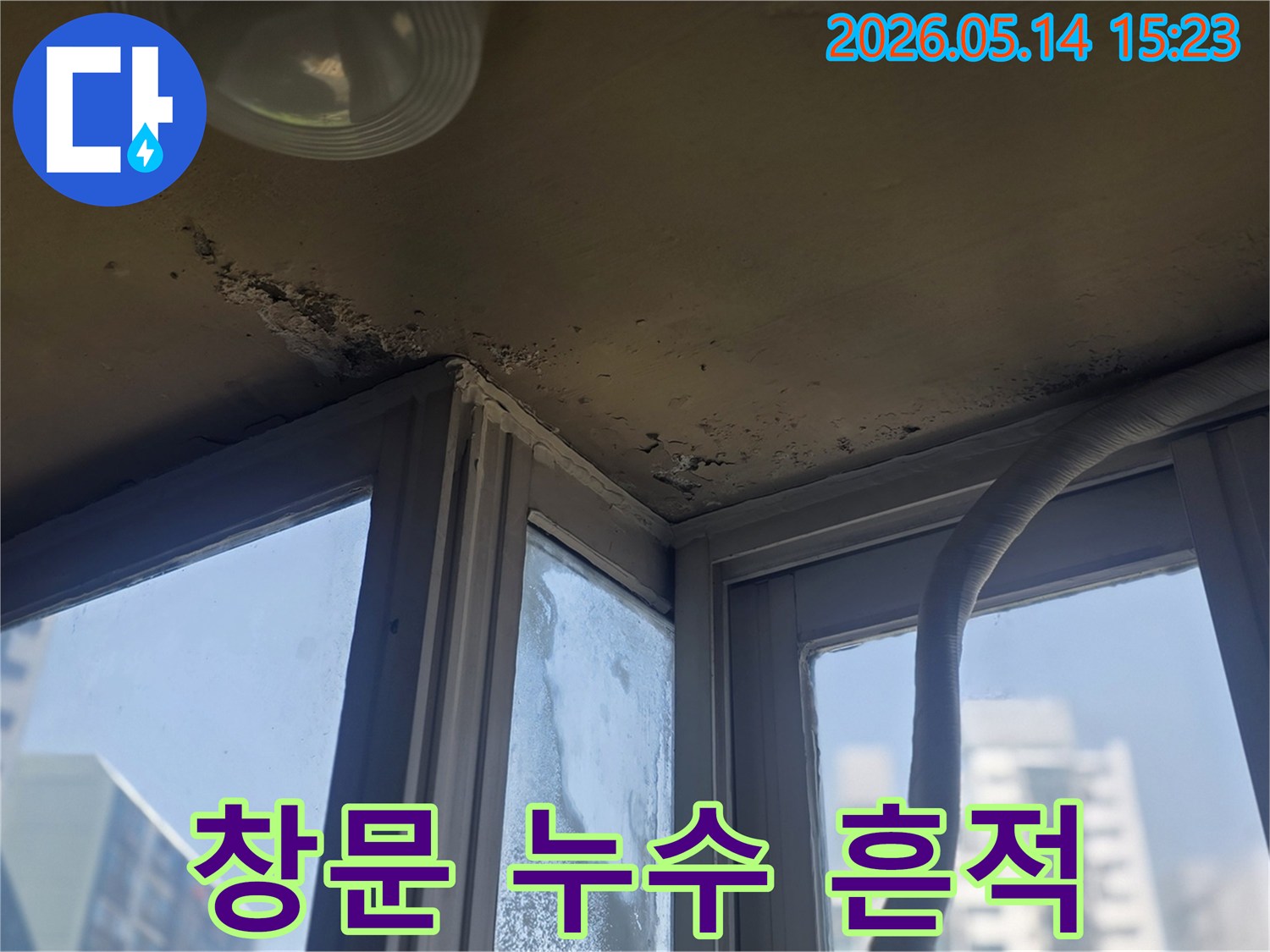 창문 주변 벽면과 천장에 나타난 누수 흔적과- 곰팡이를 보여주는 사진입니다