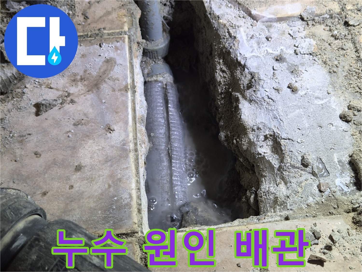 더우개마을-동일아파트에서-누수-탐지-후-바닥을-개방하여-발견된-누수-원인-배관과-주변에-고인-물을-촬영한-사진입니다.