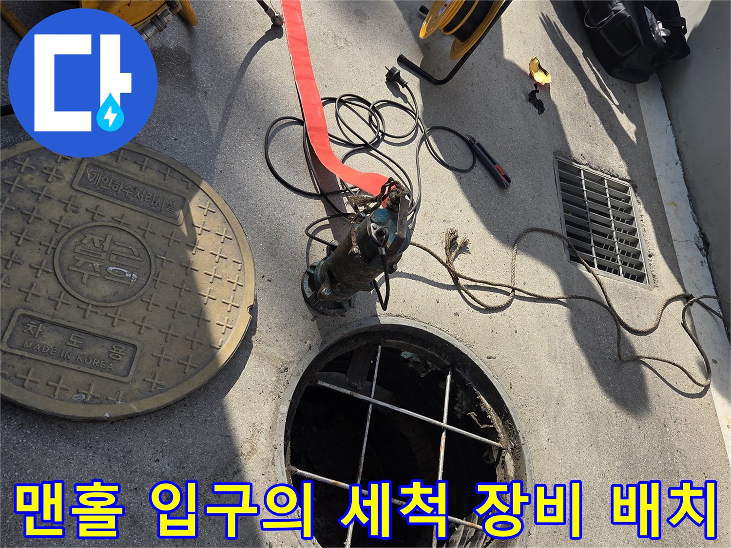 맨홀 근처에 놓인 고압 호스와 작업용 어댑터 상세 사진입니다.