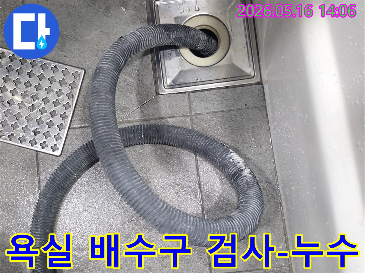 욕실 바닥 배수구에-누수 탐지용 호스를 삽입하여-정밀하게 검사하는 작업 모습입니다.