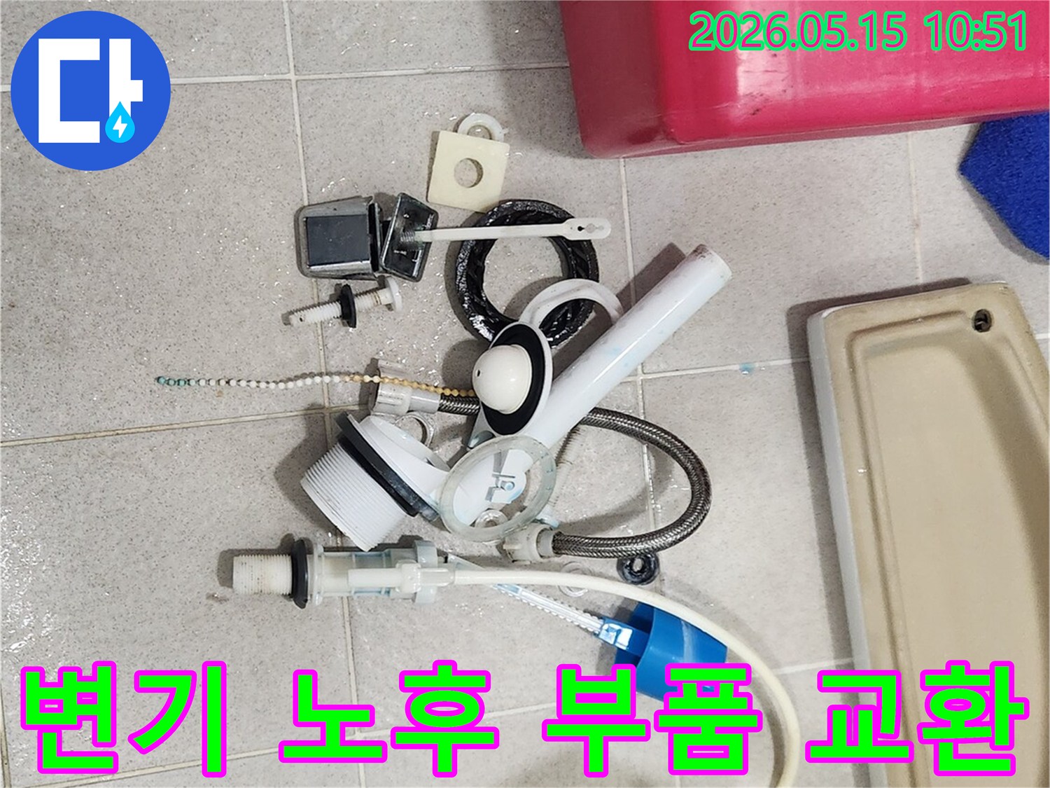 오랜 사용으로 기능이 저하된 변기 부속품들이-바닥에 놓여-새 부품으로 교체될 준비를 하고 있습니다