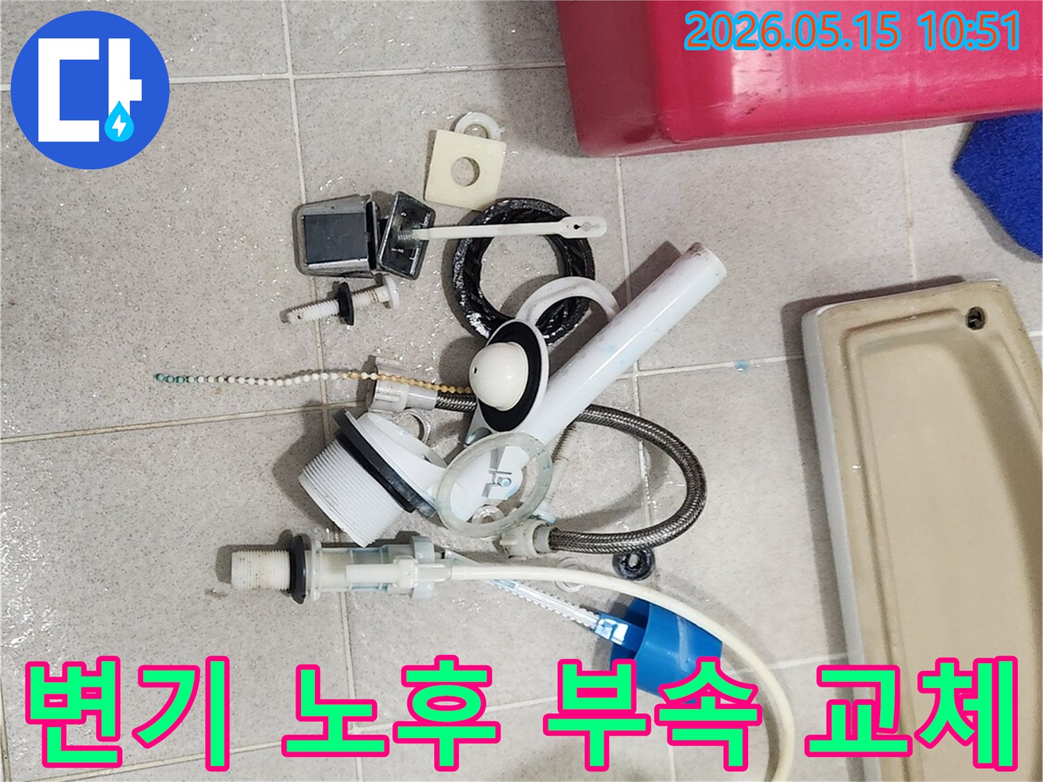 오랜 사용으로 기능이 저하된 변기 부속품들이-바닥에 놓여-새 부품으로 교체될 준비를 하고 있습니다