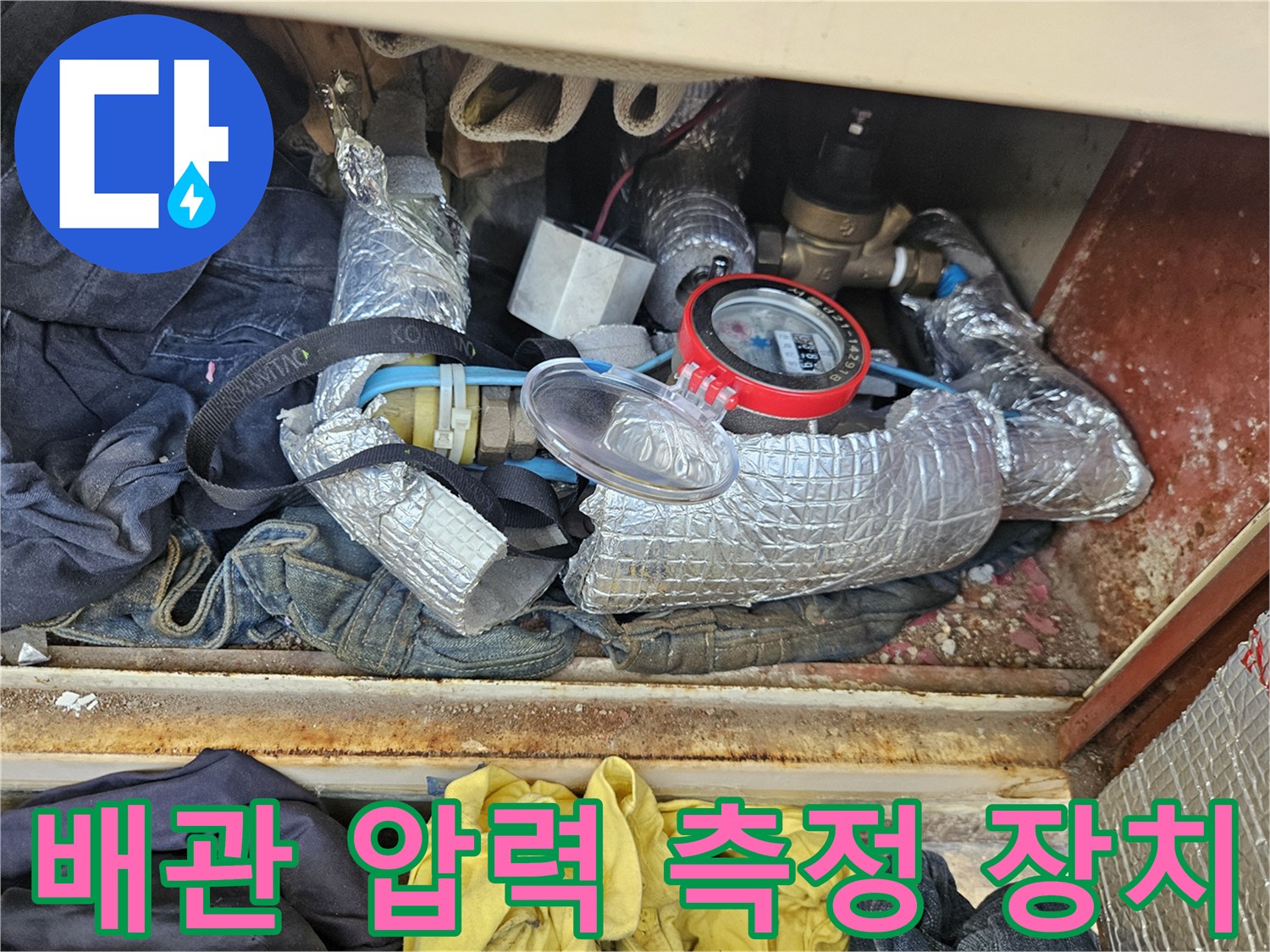 보온재가 감싸진 배관과 붉은색 테두리의 압력계