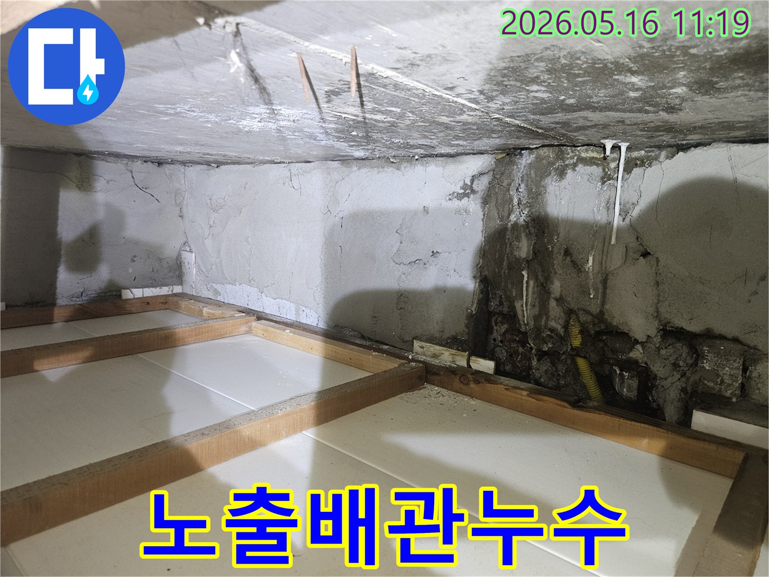 지하-벽면에서-콘크리트가-손상되고-노란색-노후-배관이-노출된-누수-현장