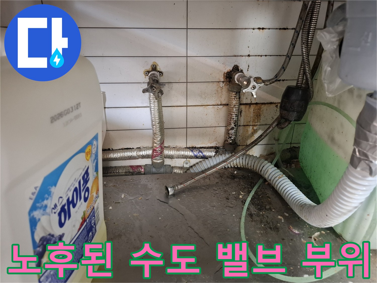 습기로 인해 변색된 벽면 타일과 수도 연결 배관