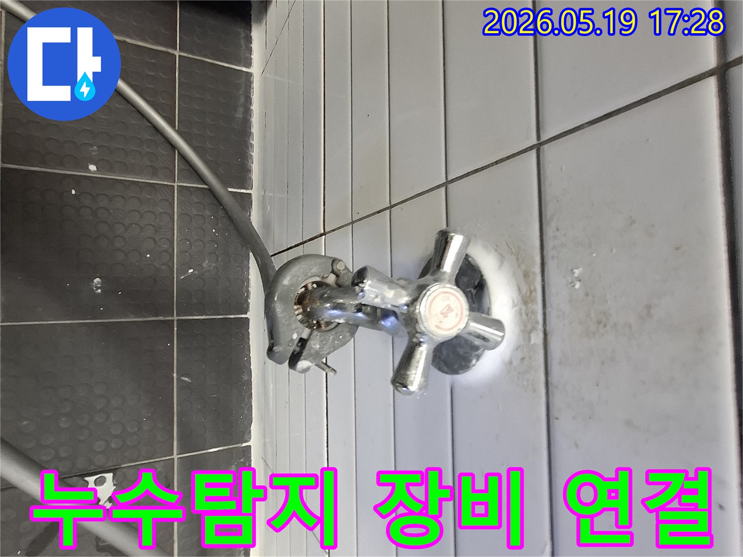 타일 벽면에 설치된 누수 탐지 장비-수도꼭지 연결부위-누수 원인 파악 중