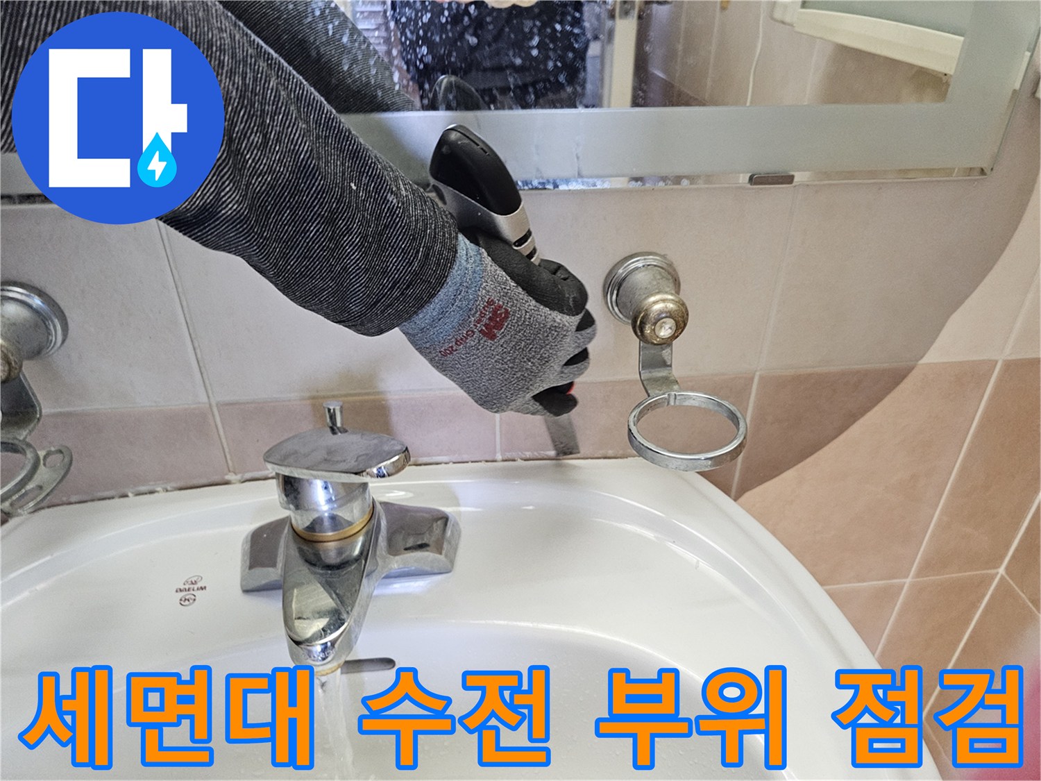 세면대 아래쪽 벽면 배관과 수전이 연결된 지점의 마감 상태를 엔지니어가 검사합니다.