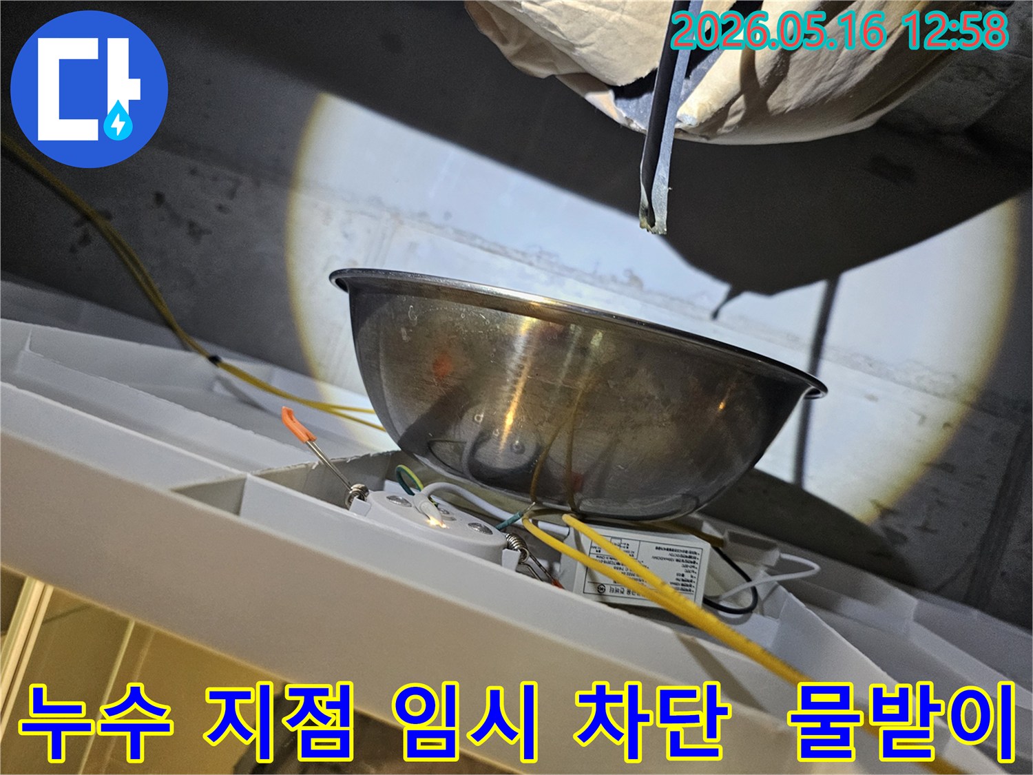 아파트 천장에서 발생하는 누수를-스테인리스 볼로-임시로 받아내며-전기 설비의-안전 여부를-점검하는 현장