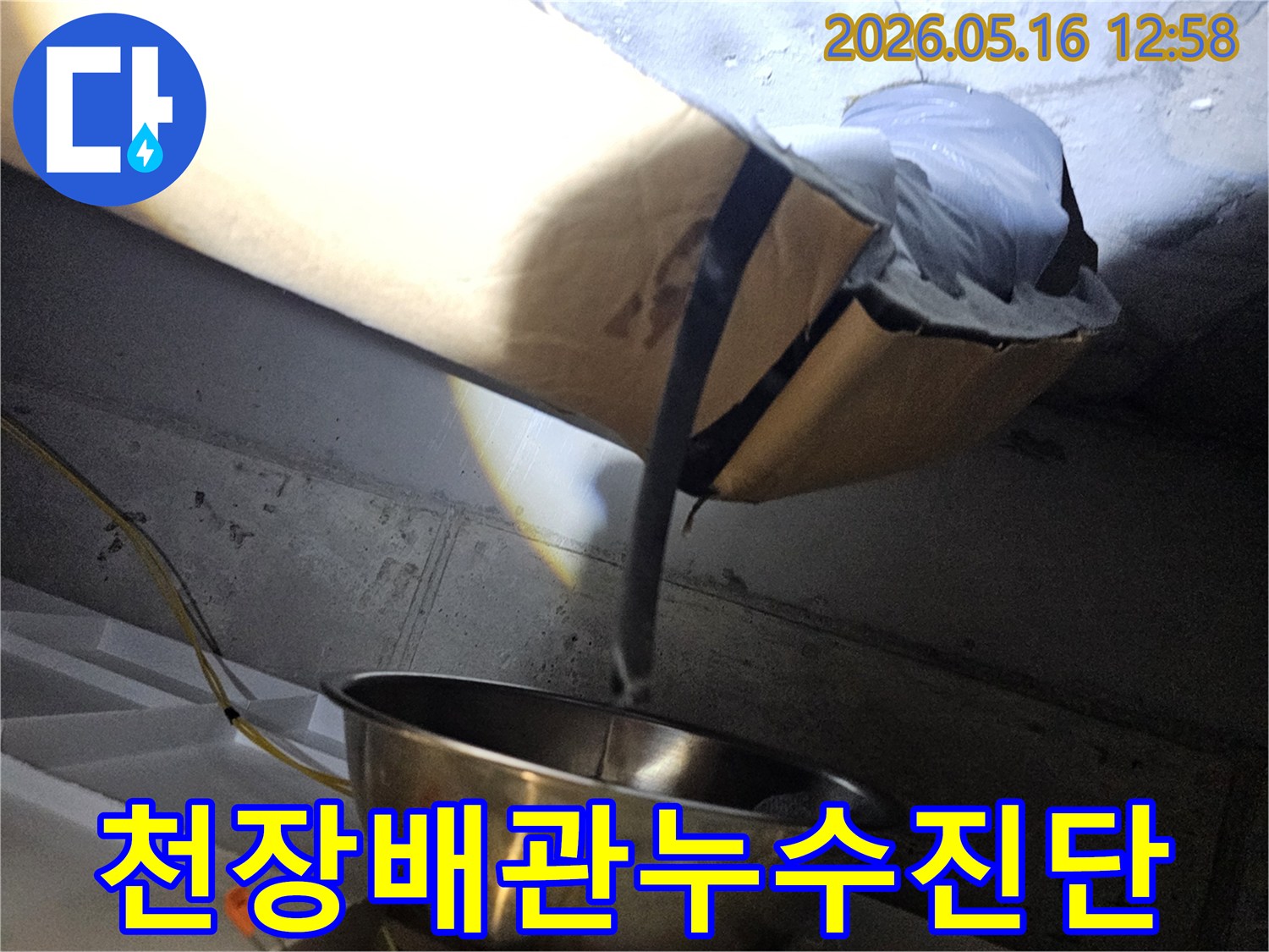 천장 내부의-배관과 보온재에-발생한 누수 흔적을-조명으로 비춰-확인하는 현장 사진입니다.