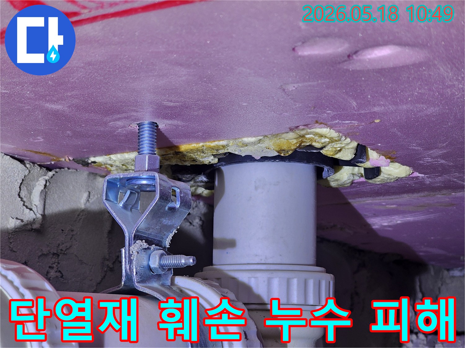 천장 단열재가 물에 젖어 훼손된 모습과-주변 배관의 상태를 보여주는-누수 피해 현장 이미지입니다.