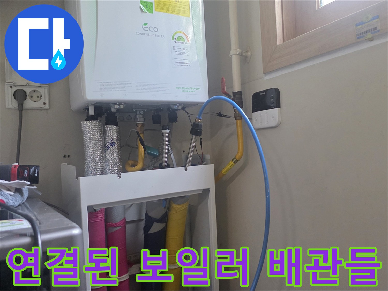 보일러 하단부의 다채로운 색상 배관과 연결 부위 상세 사진