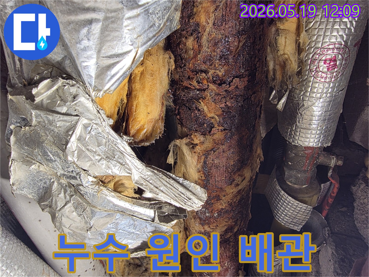 단열재가 젖어-부식된 배관이 드러난-누수 발생 현장의-근접 사진