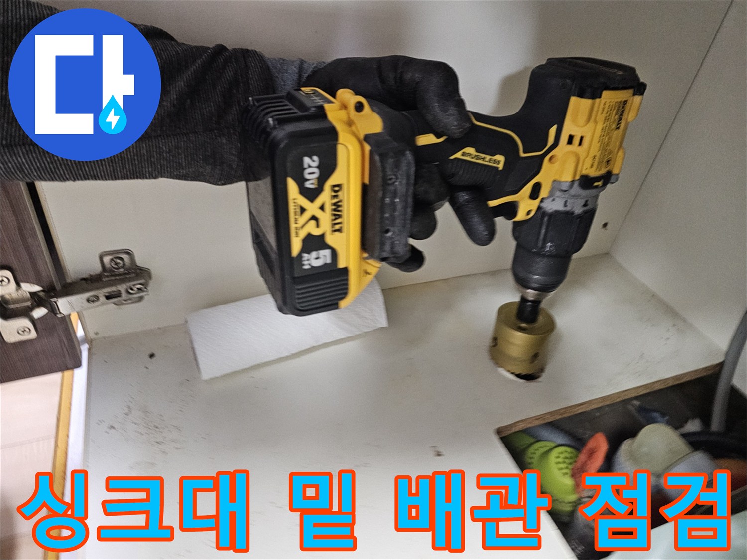 싱크대 하부 공간에서 배관 상태를 확인하는 전문 장비와 손