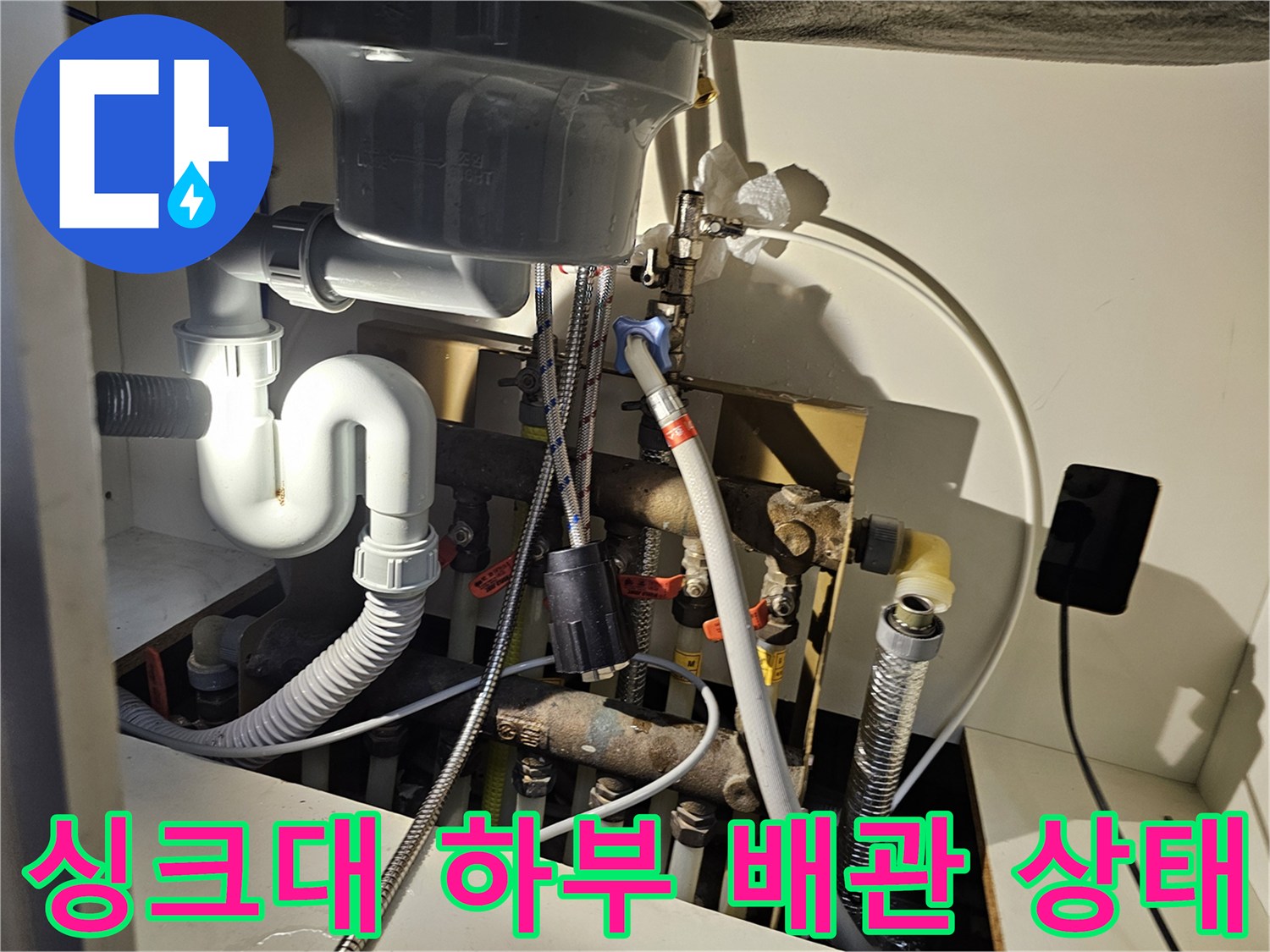 싱크대-하부장-내부의-복잡한-배관과-연결부-점검-모습