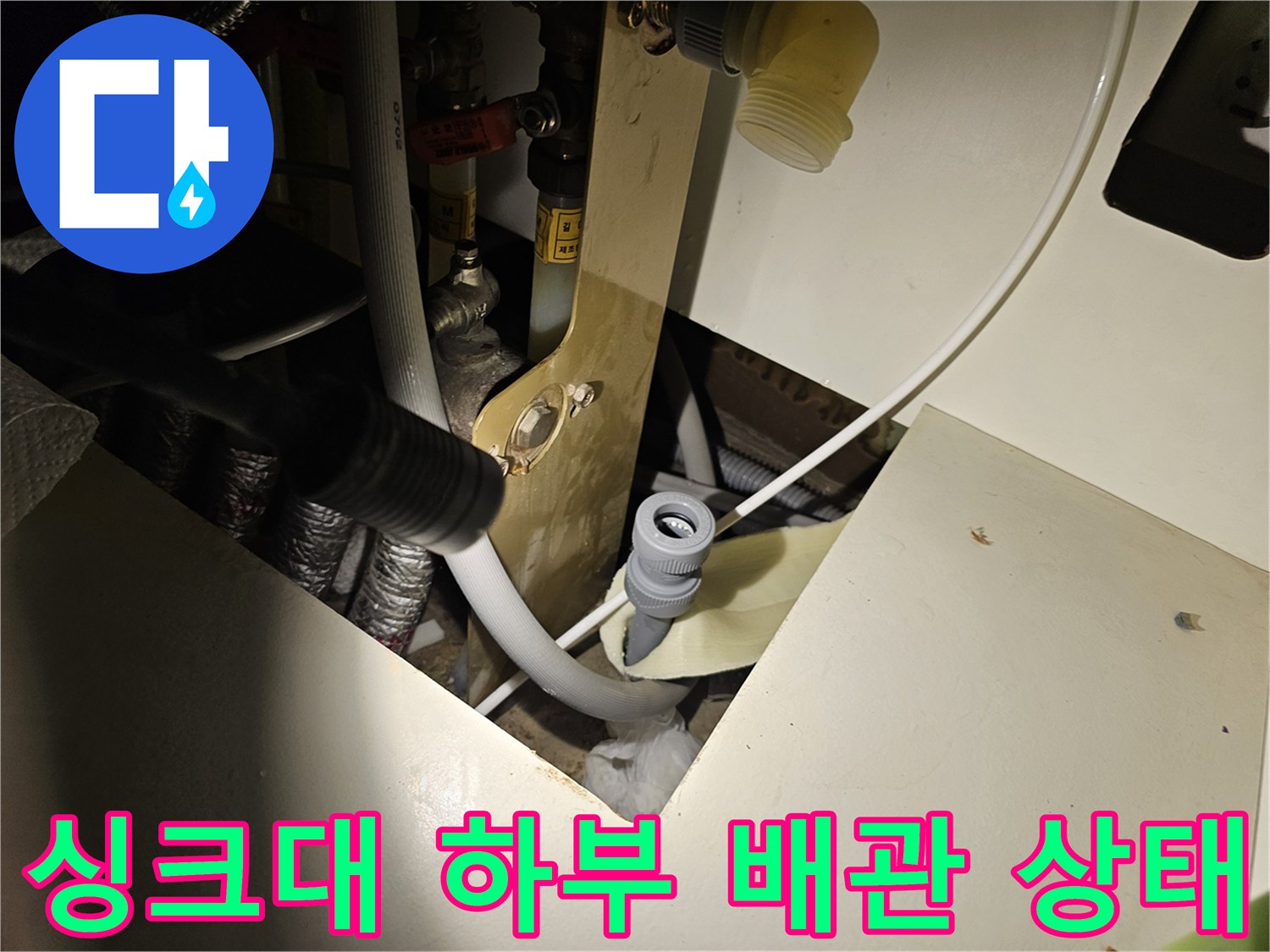 주방 싱크대 하부장 내부의 배수 배관과 연결 부위 모습