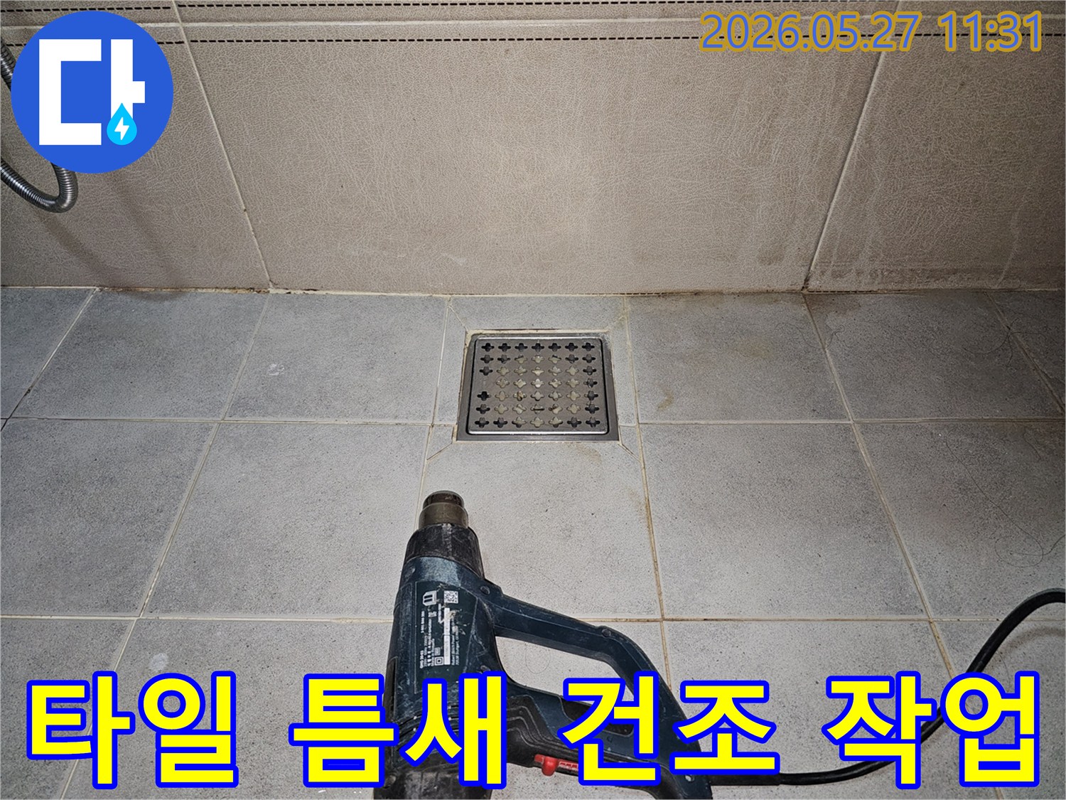 누수 엔지니어가-욕실 타일 틈새의-습기를 열풍기로 제거하며-정밀 탐지를 준비하고 있습니다