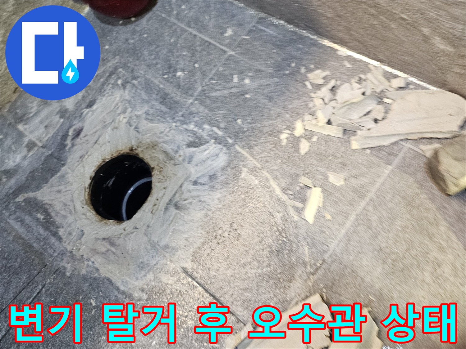 변기를 제거한 뒤 드러난 오수관 주변의 방수층 상태를 보여주는 사진입니다.
