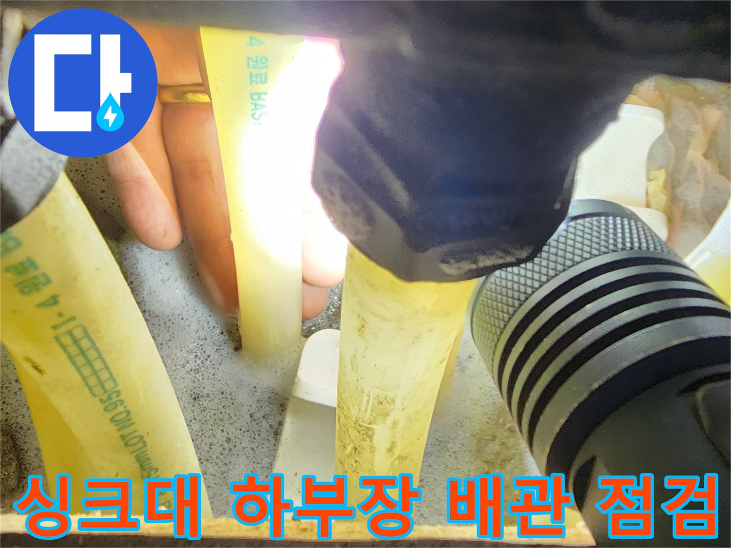 손전등으로 비춘-싱크대 하부장 분배기 배관 상태