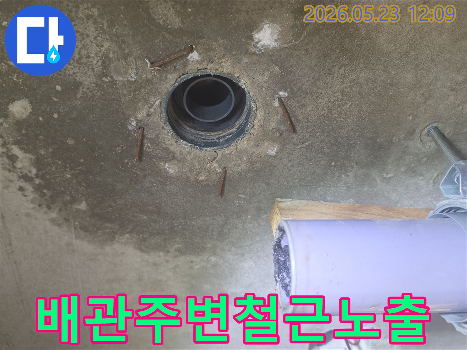 낡은 배관과-주변 콘크리트의 손상-그리고 노출된 철근을 담은 누수 공사 전 사진입니다.