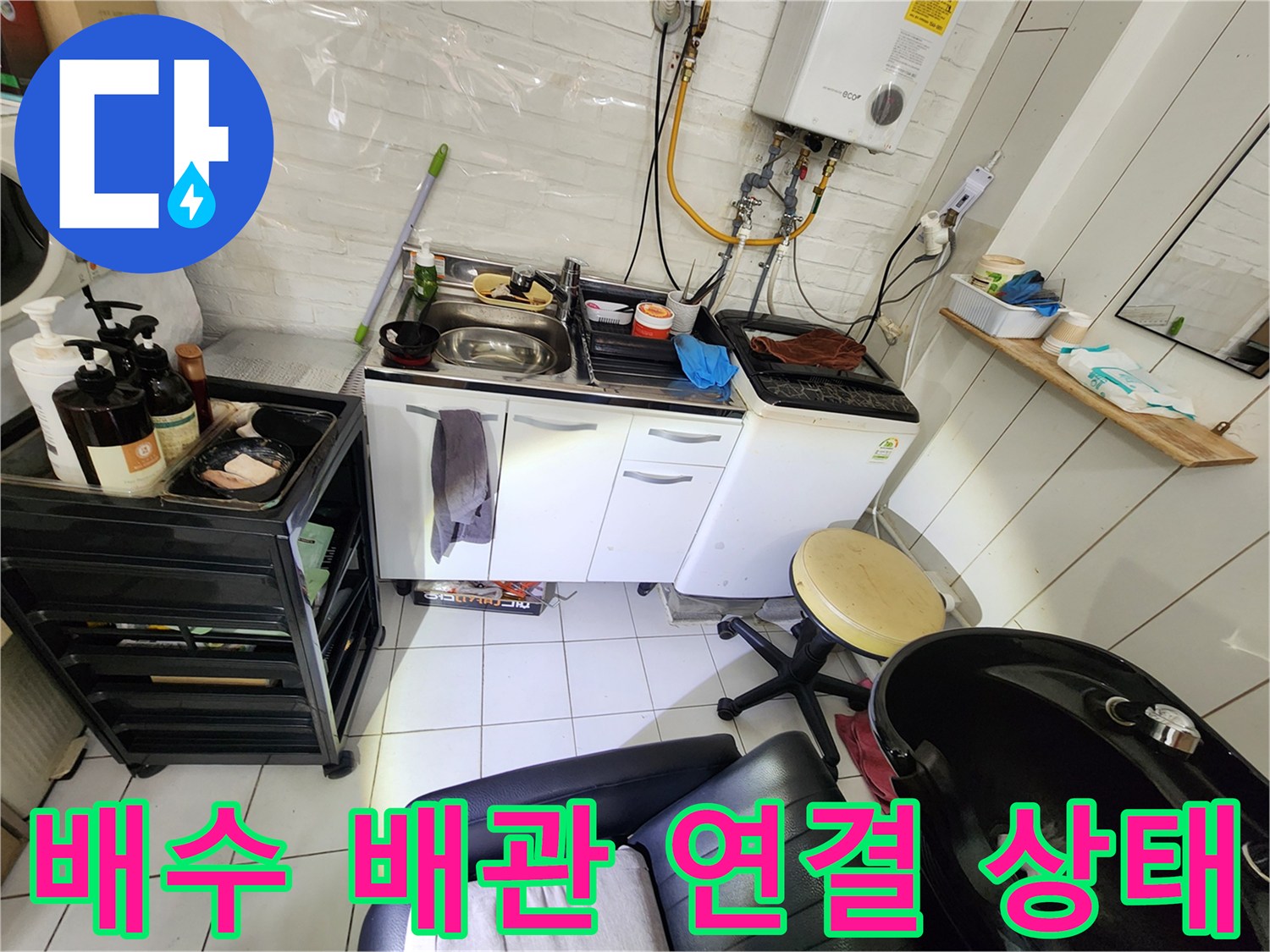 싱크대 하부 배수 호스와 벽면 관통 부위의 상세 모습