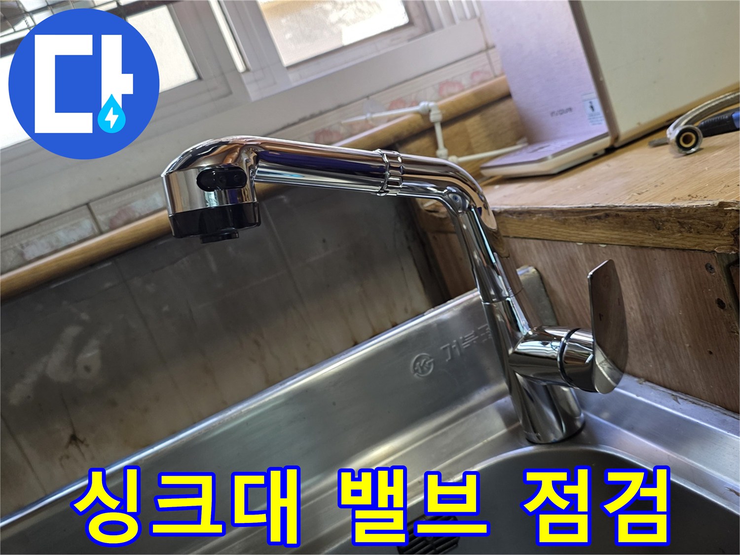 스테인리스 싱크대에 설치된 은색 수전과 밸브 부위