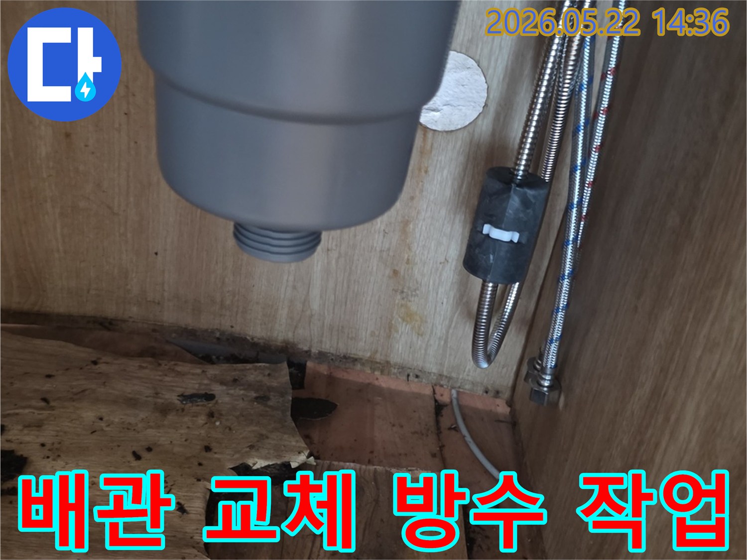 싱크대 하부장 내부의 손상된 배관과-물에 젖어 부식된 목재-그리고 배관 교체 및 방수 작업이 필요한 누수 현장