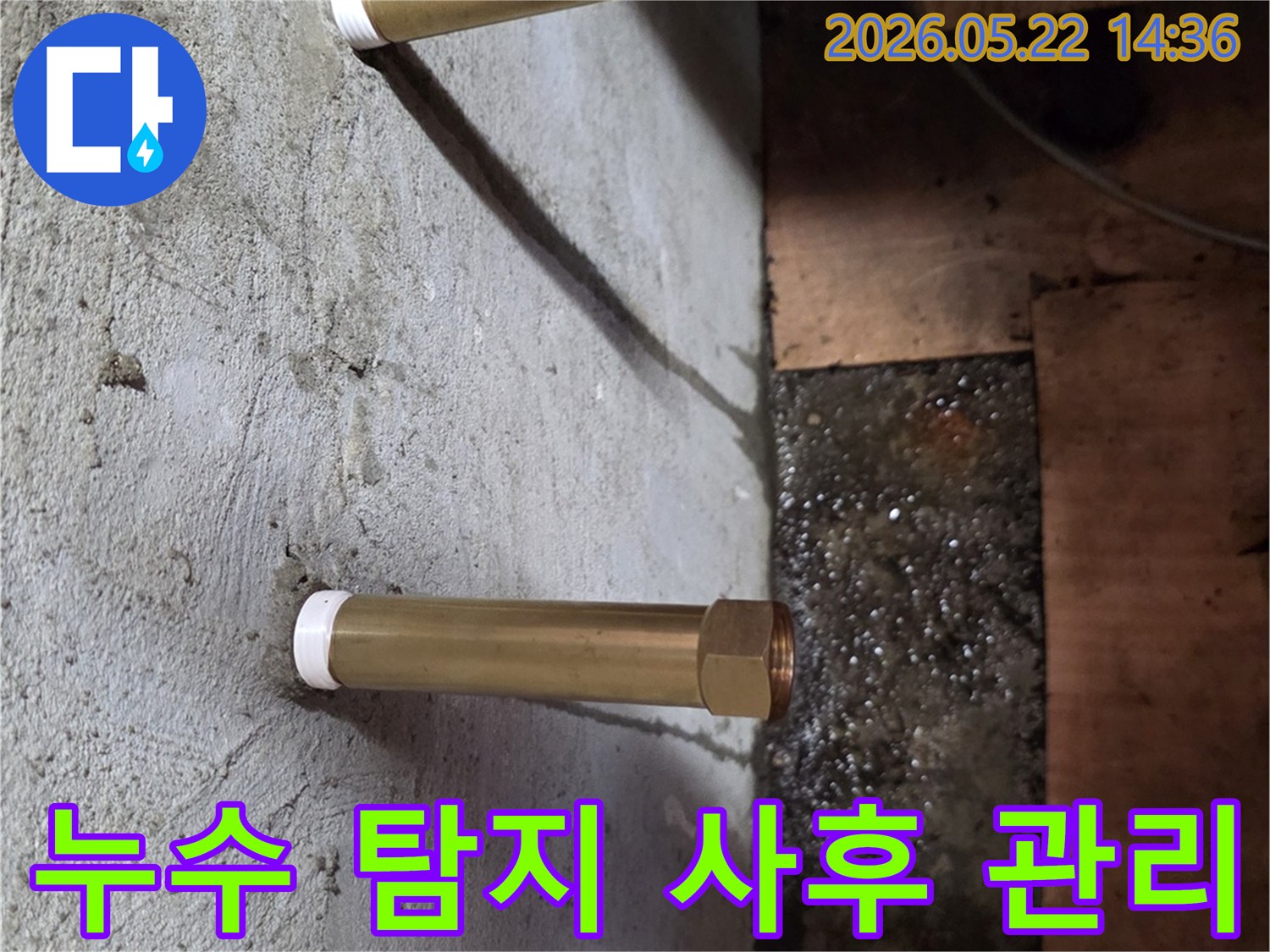 천장에서 내려온 금속 배관 아래로 물이 고여있는-누수 현장을 탐지한 후 사후 관리까지 책임지는 모습입니다.