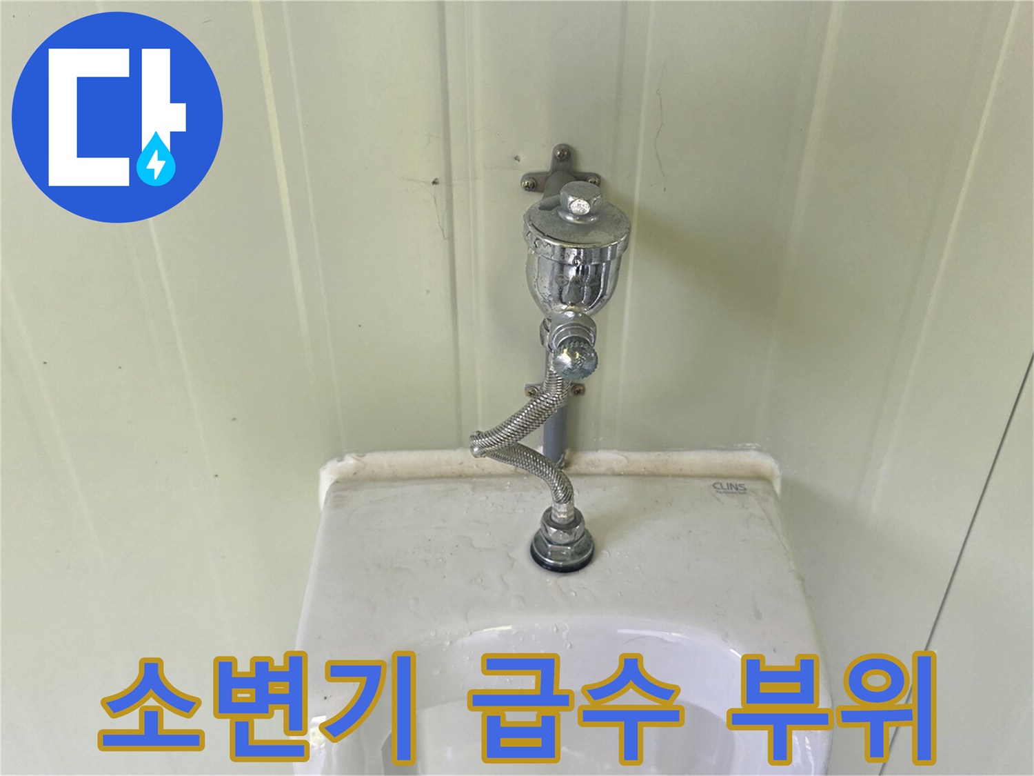 벽면 소변기에 연결된 은색 금속 밸브 상세 사진
