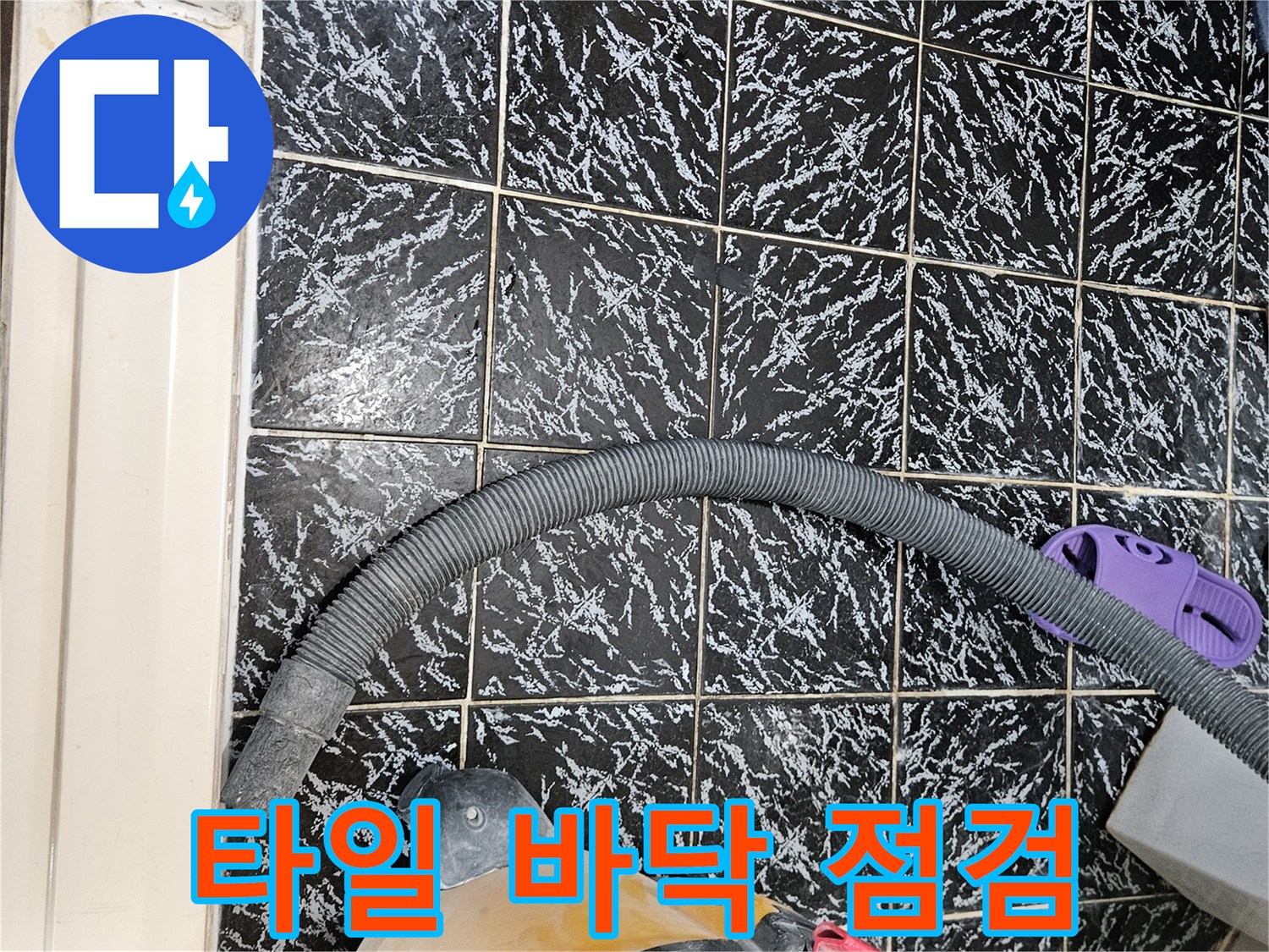 검은색 패턴 타일 위에 놓인 산업용 청소기
