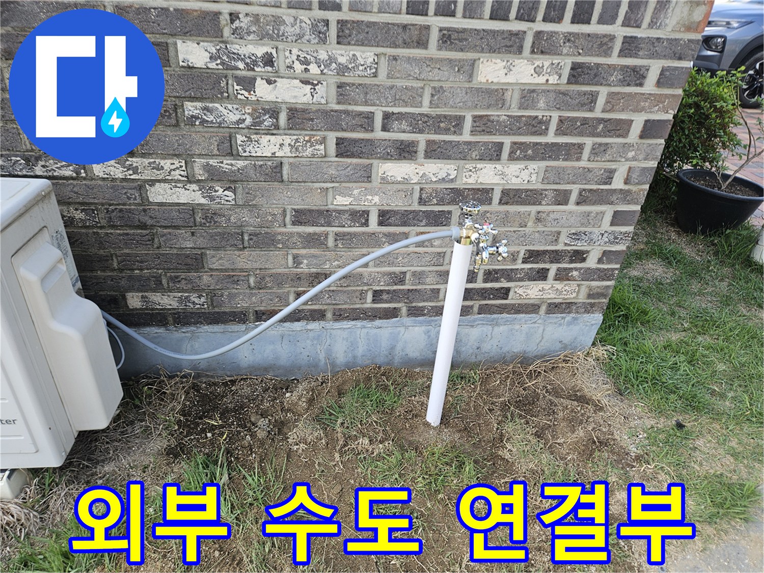 외벽 벽돌 구조물에 연결된 외부용 수도 배관