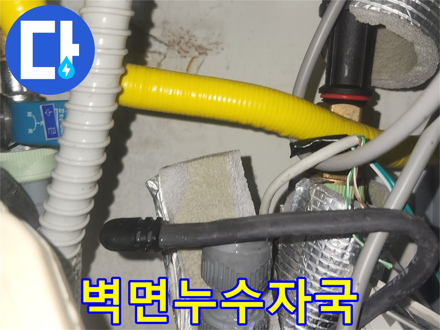 벽면에 나타난 누수 자국과-얽혀있는 배관들이 문제의 심각성을 보여줍니다-전문적인 누수 탐지 기술이 요구됩니다