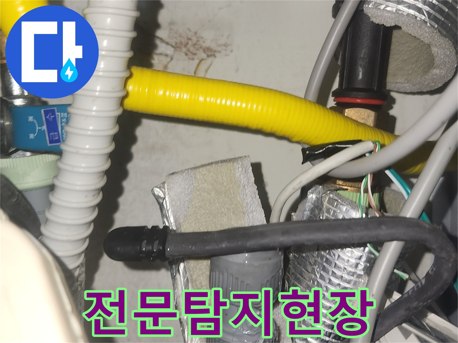 오래된 누수 흔적이 보이는 벽면과-그 주변을 둘러싼 복잡한 배관들이 담겨 있습니다-전문적인 시각으로 문제를 분석해야 합니다