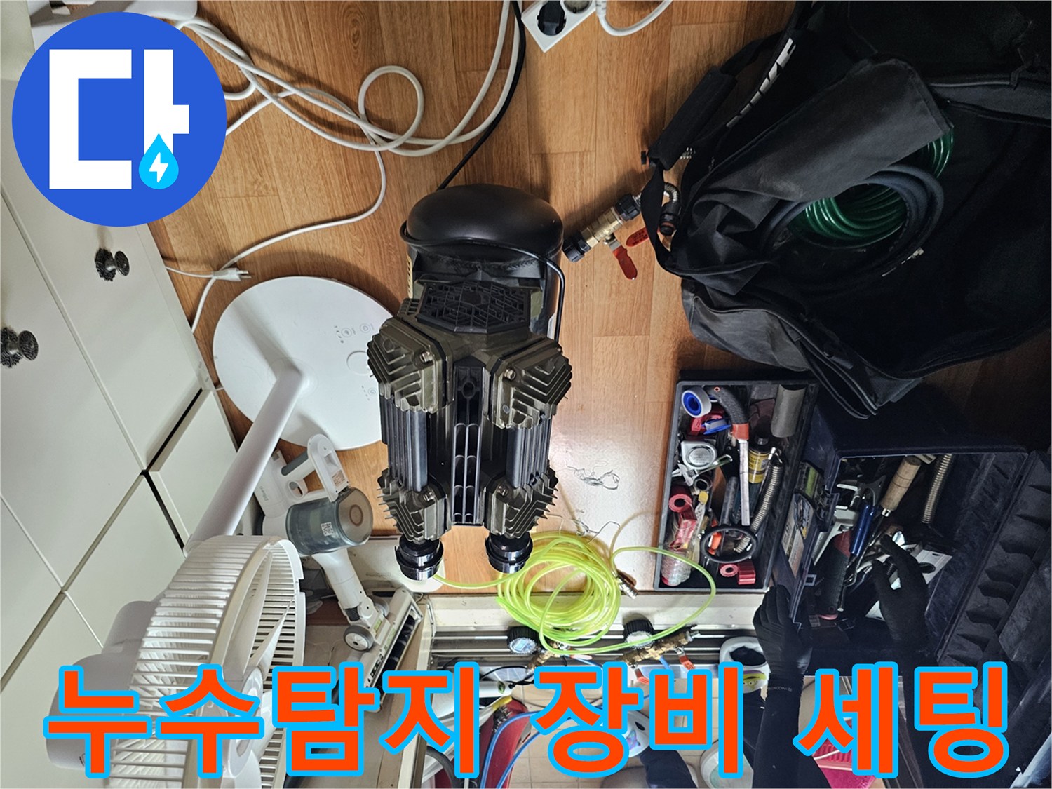 싱크대 하부 누수 진단을 위해 배치된 공압 테스트용 컴프레셔와 각종 배관 공구들