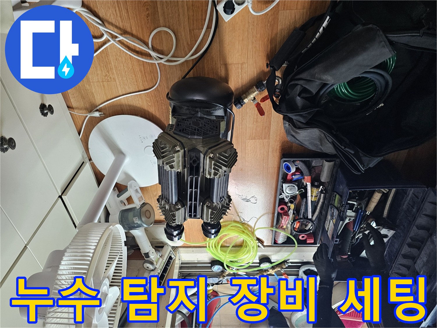싱크대 하부 점검을 위해 배치된 공압 테스트용 컴프레셔와 각종 배관 공구들입니다.