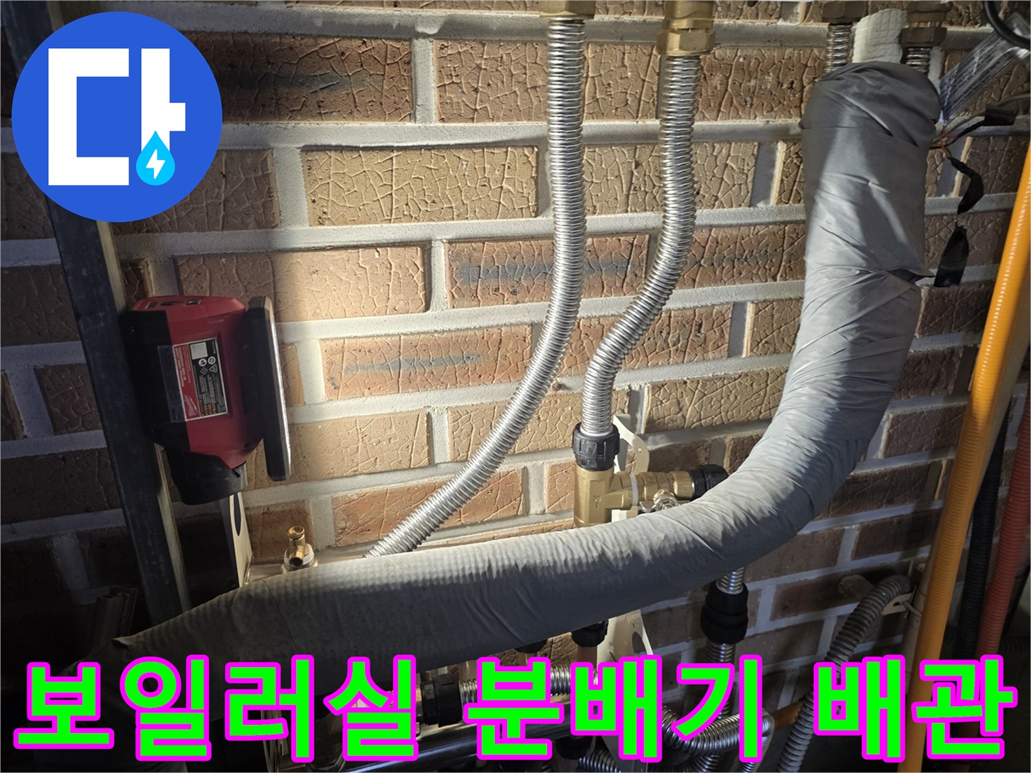 벽돌 벽면의 은색 주름관과 분배기 연결 부위 근접 촬영