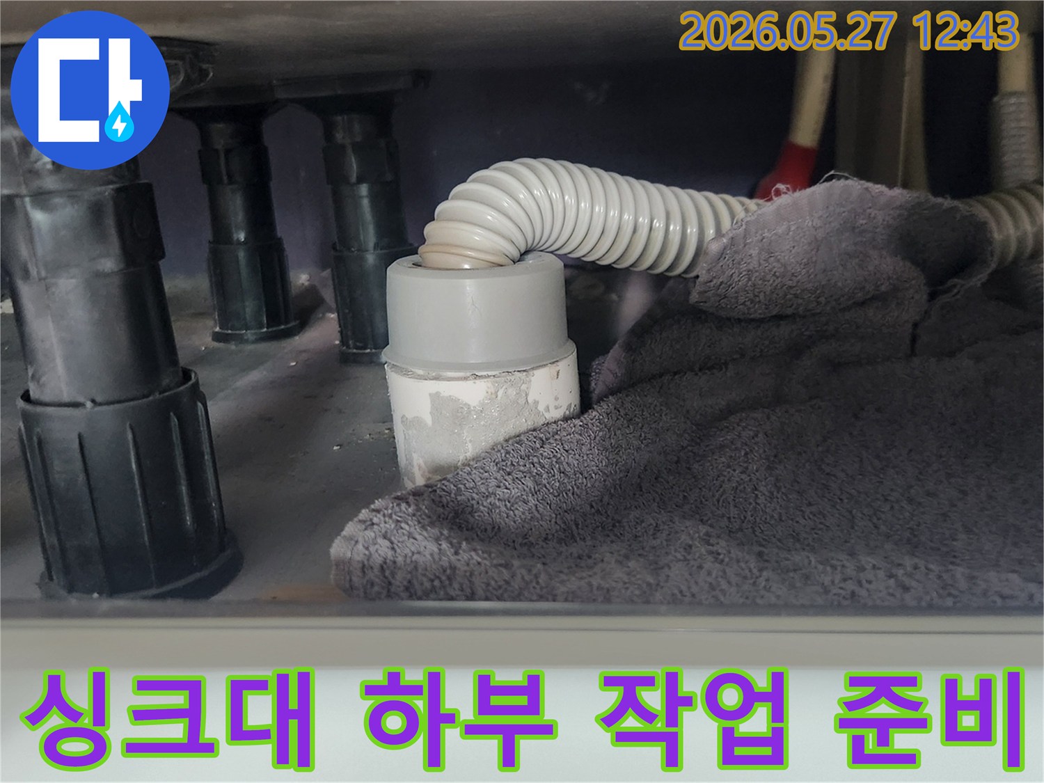 싱크대 배관 작업 전-하부 공간을 보호하고-이물질 유입을 차단하기 위해-수건을 놓아둔 모습입니다