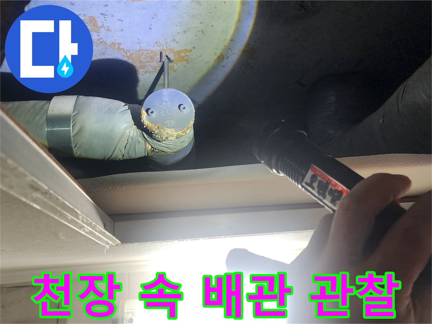 손전등 빛에 드러난-천장 내부의 배관과 구조물