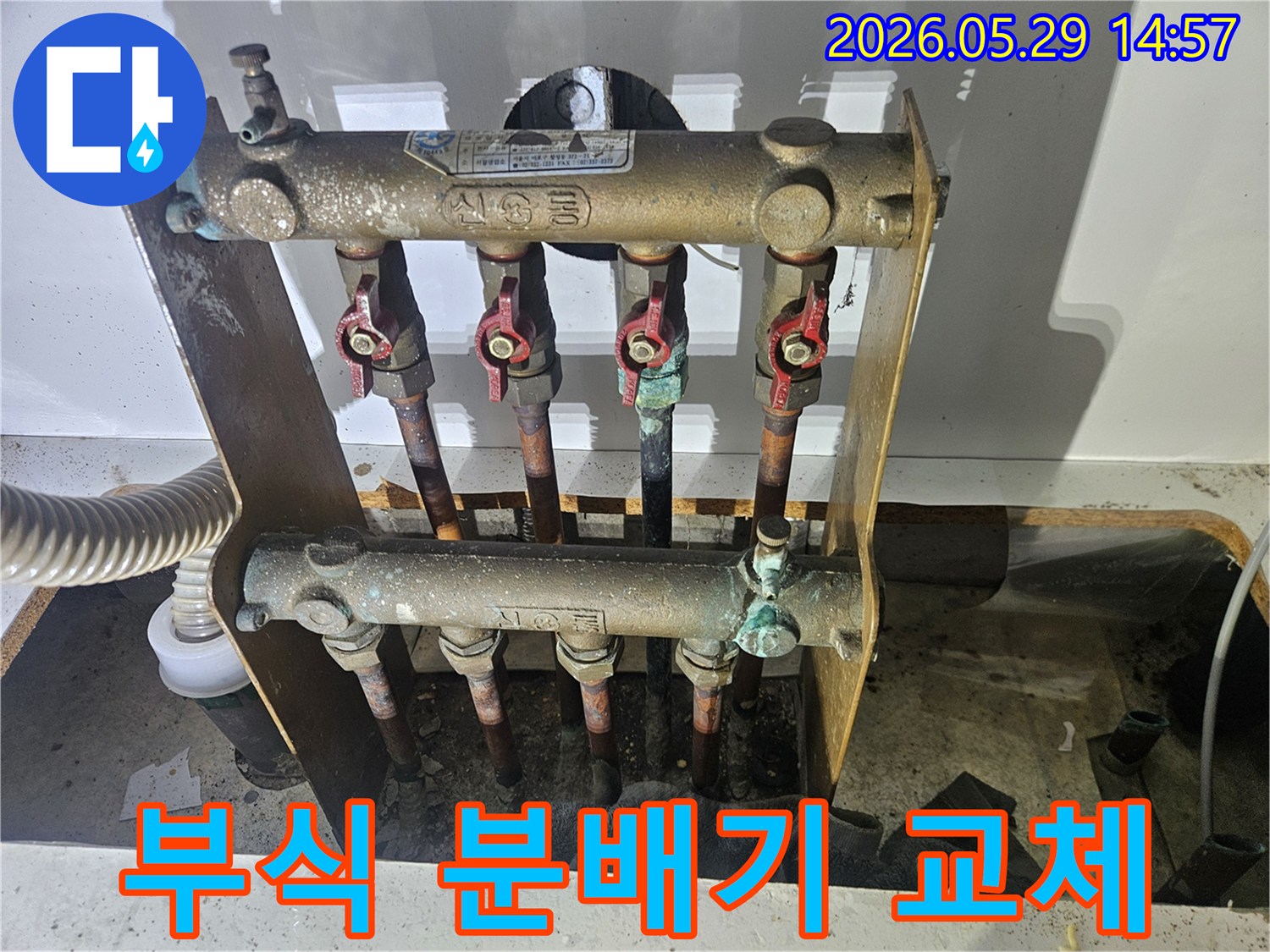 오래된 아파트의 난방 분배기에서-심각한 부식과 함께 누수 흔적이 발견되어-전문가가 교체 작업을 준비하고 있습니다.