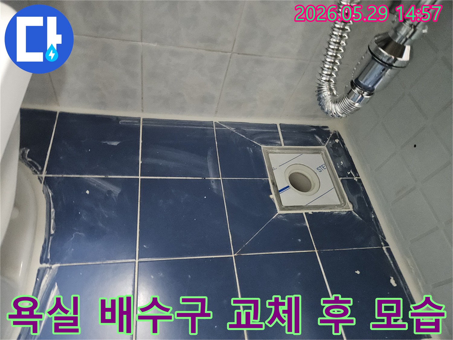 욕실 바닥에 새로 설치된 배수구와-주변 타일-그리고 유연한 배수관이-보이는-누수-공사-현장-사진입니다