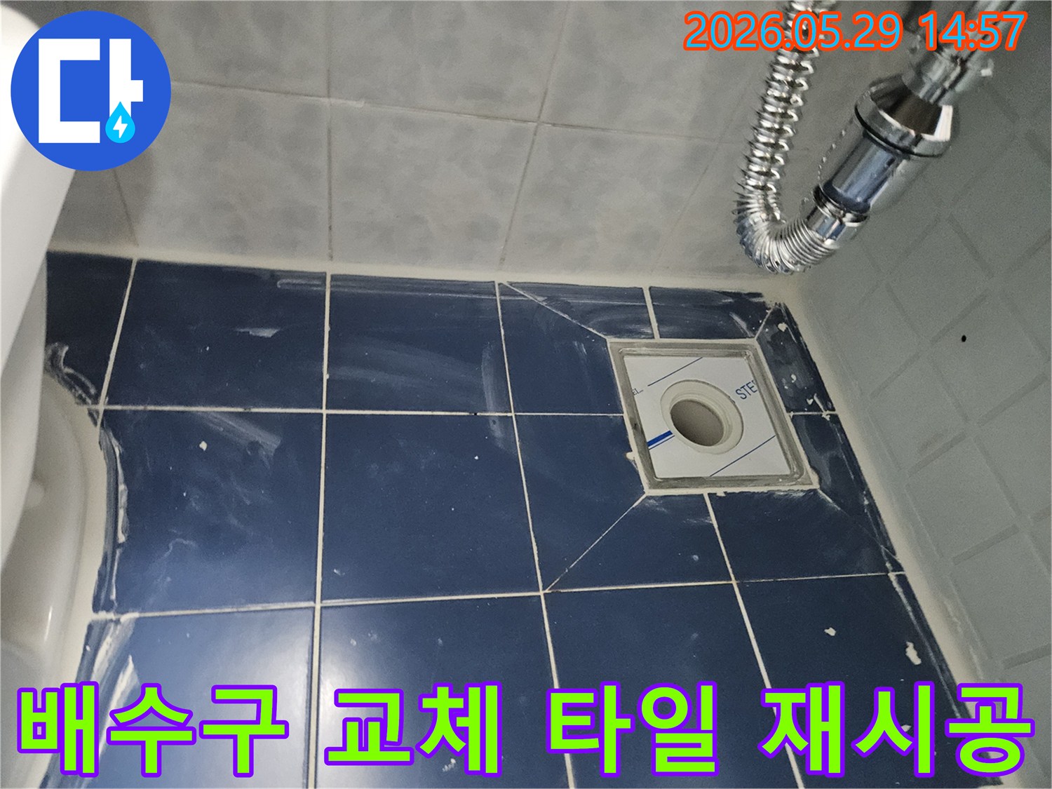 욕실 바닥에-새로운 배수구가-설치되고-주변 타일이-깔끔하게-재시공된-누수-공사-현장-사진입니다