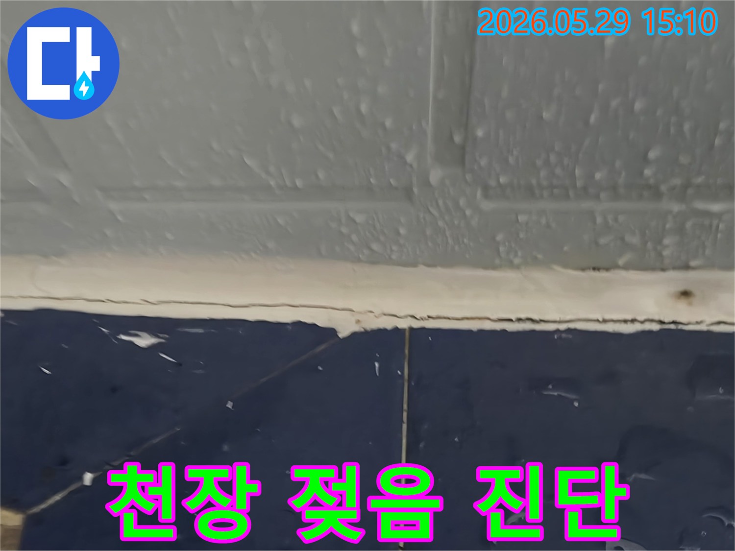천장과 벽면 경계-물이 스며들어 축축하게 젖어있는 모습-누수 전문가가 정밀 진단 중