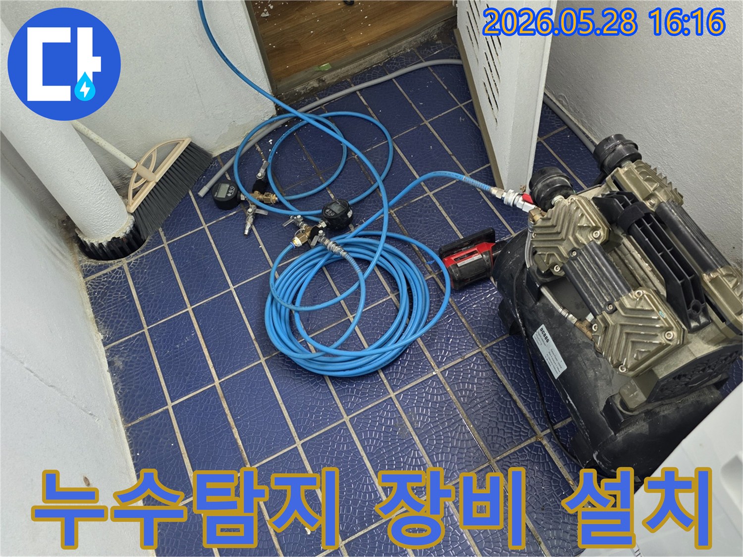 누수-원인을-찾기-위해-배관에-연결된-공압-장비와-압력-게이지-그리고-파란색-호스가-보이는-작업-현장-모습