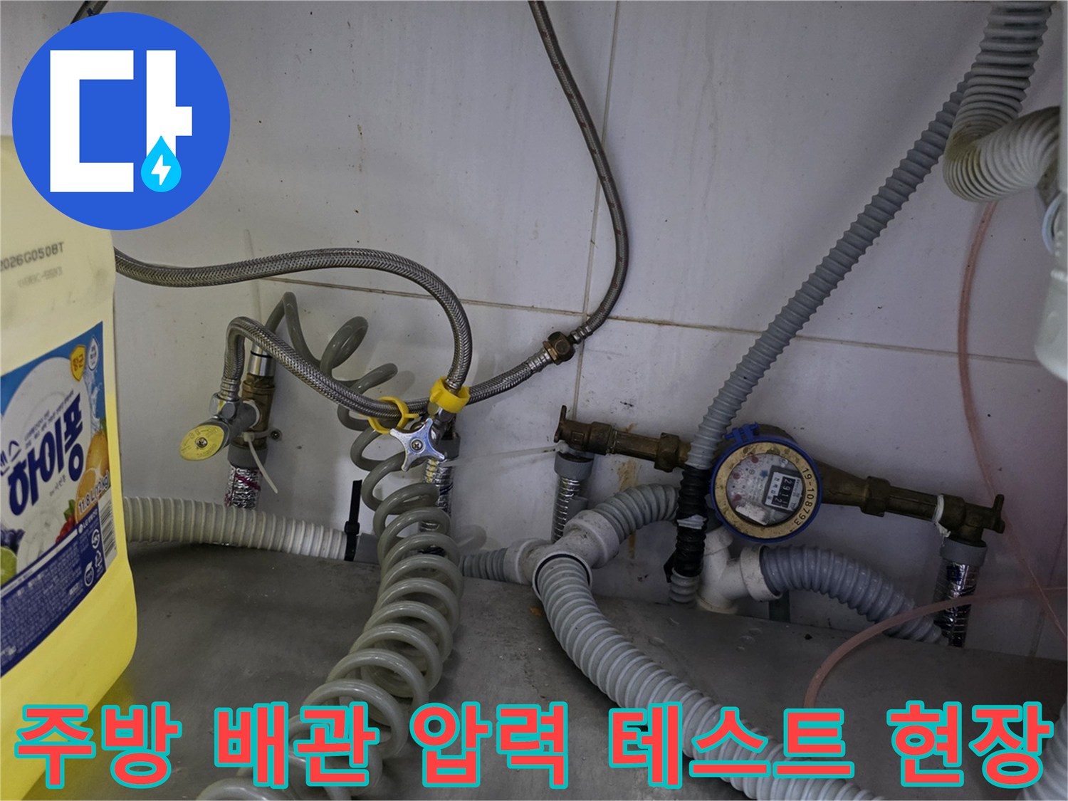 식당 주방 하단 - 수도 계량기와 연결된 파란색 호스를 이용한 배관 압력 검사 장면