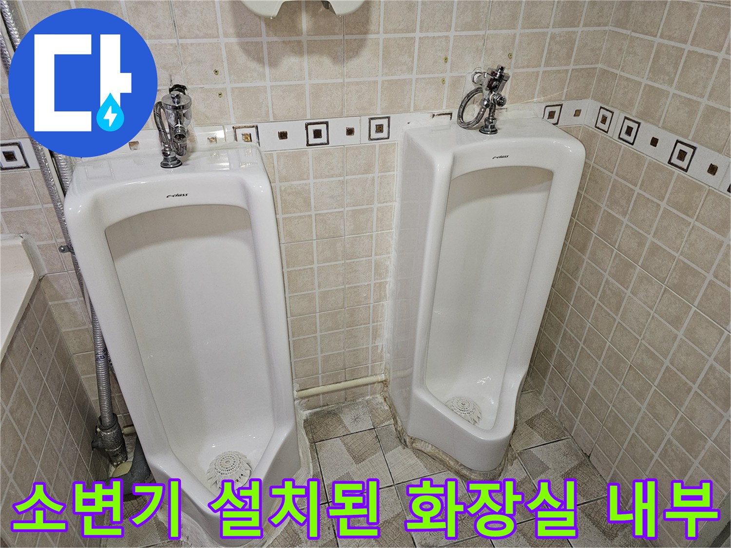 깨끗한 타일 벽면에 설치된 소변기와 급수관의 모습입니다.