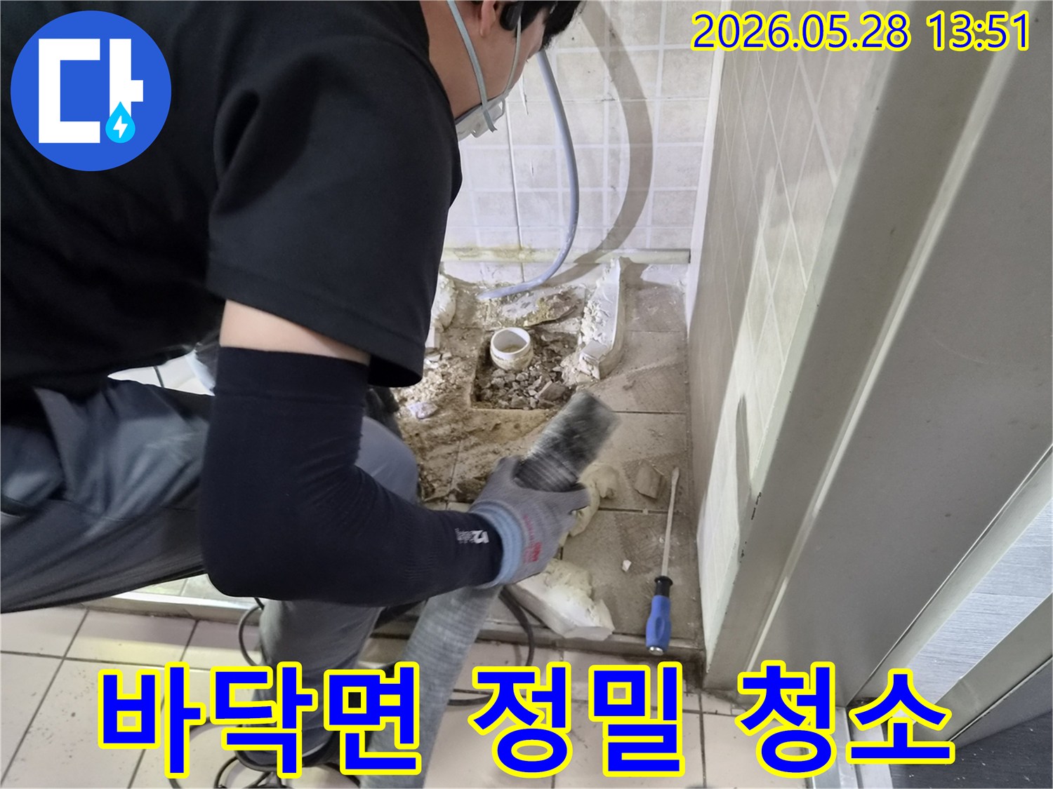 누수 공사 전문 기술자가-바닥 배관 수리 후-발생한 잔해물과 먼지를-흡입기로 정밀하게 청소하고 있습니다.