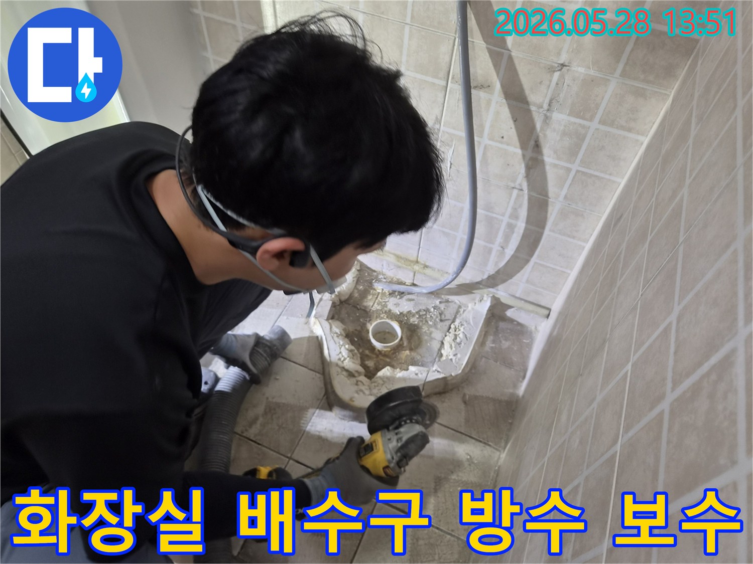 누수 전문 엔지니어가-안전 장비를 착용하고-화장실 배수구 주변의-손상된 방수층을-그라인더로 조심스럽게 제거하는-보수 작업 현장