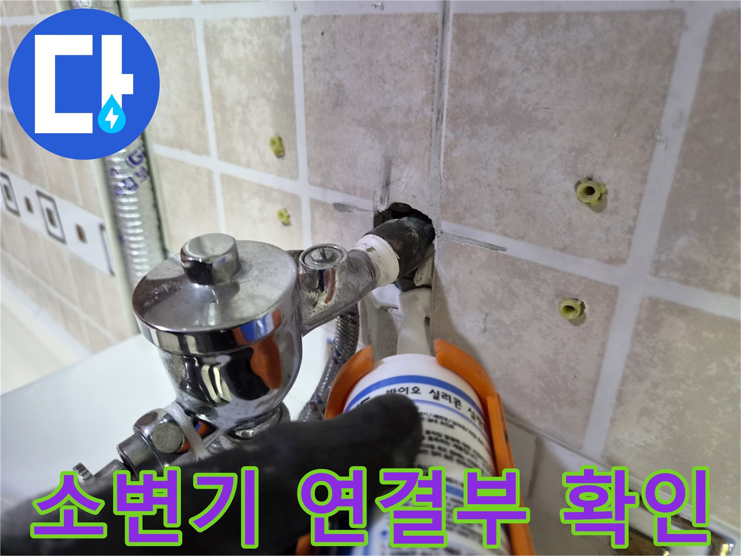 소변기 밸브와 벽면 타일 사이의 누수 여부를 점검하는 작업 사진